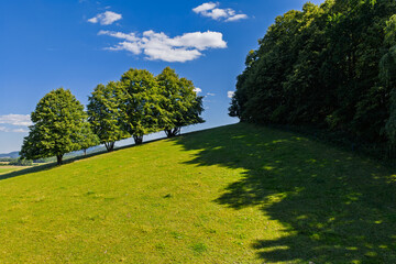 Aerial drone view of Zulova town in the Czech Republic historic church on Bozi Hora hill, traditional rooftops, surrounding greenery, and the peaceful town layout captured in clear daylight