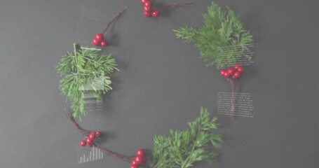 Displaying wreath of pine sprigs and glossy red berry clusters on dark gray table, with overlays
