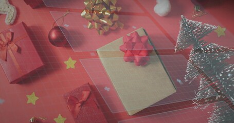 Displaying kraft-paper gift box resting on red surface, with red bows, gold bow, snowy trees