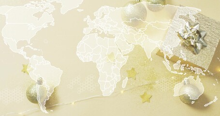 Fototapeta premium Sitting wrapped giftbox silverbow right on pale gold table, with ornaments, lights, map, copy space