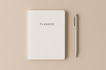Simple planner and pen displaying productivity, planning, and scheduling tools on a neutral beige background in a flat lay