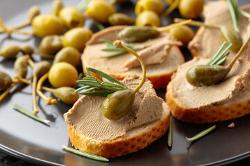 Sandwiches with pate on a black plate.