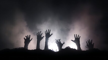 Silhouetted skeletal hands emerge from dark, smoky ground under bright backlighting