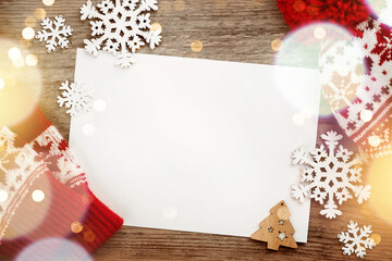 Christmas winter red hat and mittens, wooden snowflake decorations ornaments on old wooden greeting board background. Merry Christmas design element.