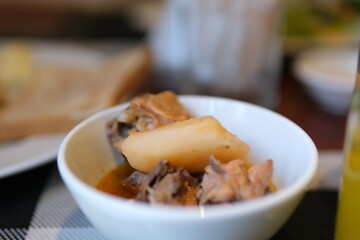 Vegetable soup with beans, potatoes, pumpkin, kale, carrots, onions and celery close-up in a bowl on the table. Horizontal top view from above . High quality photo