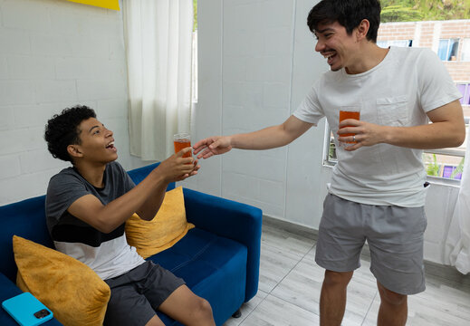 Two friends in a living room sharing a soda in a relaxed setting, conveying social interaction, friendship, and an everyday moment at home - Powered by Adobe