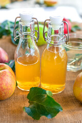 Apple cider vinegar against a background of apples. Selective focus.