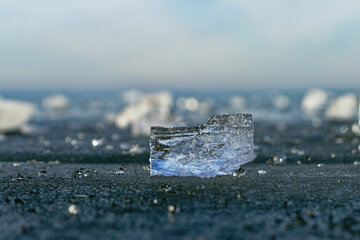 A close-up shot of a crystal-clear ice shard against a blurred backdrop.