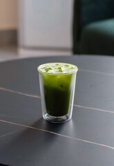 A vibrant green, refreshing iced matcha served in a double-walled glass. This simple yet striking drink is a perfect source of natural energy and antioxidants for a clear mind and a cool moment.