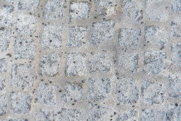 Textured stone surface with gray cobblestones and natural abrasions for realistic urban backgrounds