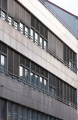 Modern office building with glass windows and external blinds in a strict minimalist urban style