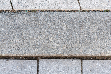 Rough textured surface of a gray granite slab with natural inclusions and uneven texture