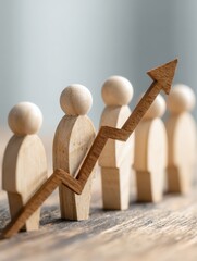 wooden figures lined up in ascending order beneath upward trending arrow graph team development collective growth organizational success strategies visualizing employee empowerment for career