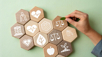 Collection of wooden hexagonal blocks arranged in a honeycomb pattern, each block displays a white icon related to health and wellness