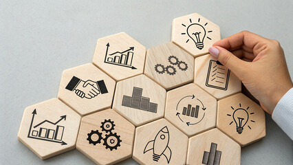 Wooden hexagonal blocks arranged in honeycomb pattern, each block displays different black icons representing various business concepts
