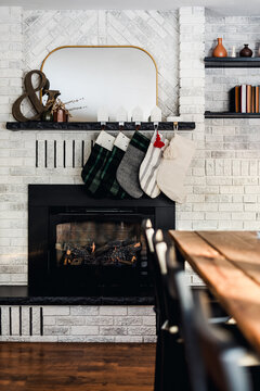 Modern Christmas Fireplace with Stockings in Cozy White Brick Living Room Interior