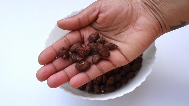 hand showing healthy snack alternative that is high quality jaggery choco coated almonds for healthy lifestyle.