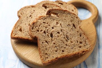 Bread slices on light wooden table, closeup