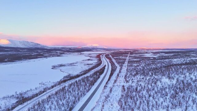Sunset over a road passing through arctic mountains landscape in Lapland, Sweden, between Kiruna and Abisko