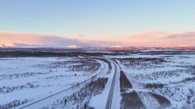 Sunset over arctic landscape in Lapland, Sweden, road and railroad between Kiruna and Narvik