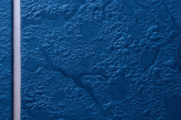 Blue embossed texture background with a white vertical strip for text. Close-up of a metallic gift box surface perfect for men&rsquo;s greeting cards. Photo