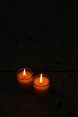 A candle burned on a glass holder in the dark, a symbol of hope.	