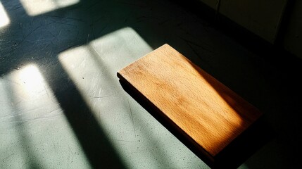 Wooden block casting shadows on a floor in soft natural light, highlighting textures and patterns in an indoor setting