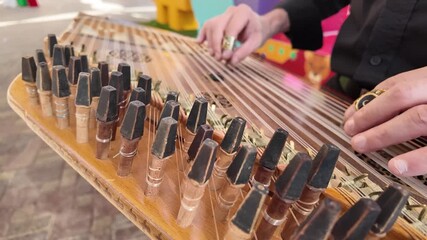 Omani guy playing on the qanun instrument  Middle Eastern music at celebration of The United Arab Emirates Independence Day ( 54th uae national day ) in Al Ain Zoo