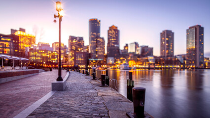 At sunset, view of the Boston Harbor and Financial District in a blurred conceptual image of the city where Taxation without Representation originated.
