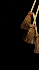 Mini witch brooms on black background, occult props, mystical composition, esoteric tools for magic and rituals