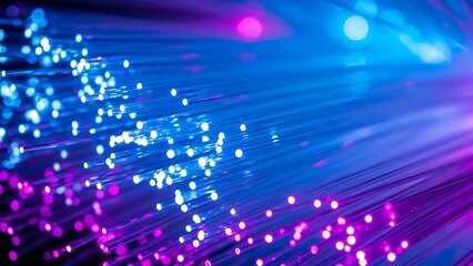 Obraz premium Close-up of glowing fiber optic cables displaying vibrant blue and purple light, representing high-speed data transmission and modern connectivity.