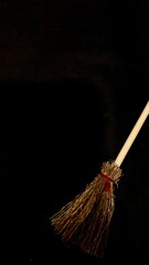 Mini witch brooms on black background, occult props, mystical composition, esoteric tools for magic and rituals