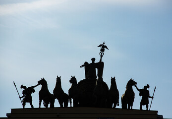 The iconic sculpture of the Chariot of Glory atop the General Staff Building in St. Petersburg, Russia, in silhouette against a clear sky. For travel, architectural, or historical content