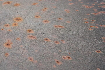 Surface with rust marks shows texture and color in a close-up view at a location with metal exposure over time