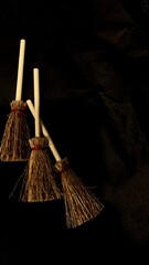 Mini witch brooms on black background, occult props, mystical composition, esoteric tools for magic and rituals