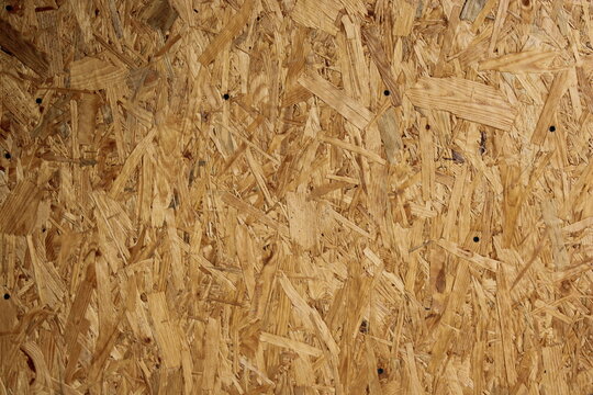 Texture of oriented strand board used in construction taken in a workshop during daytime