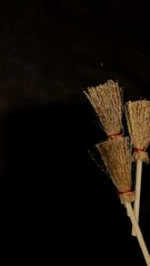 Mini witch brooms on black background, occult props, mystical composition, esoteric tools for magic and rituals