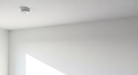 White smoke detector on a ceiling. Fire alarm system for home safety and protection. Modern technology for disaster prevention.