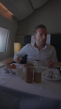 discerning gourmet relishing private jet meal with elegant table arrangement and gentle window light
