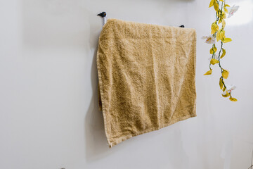 brown fluffy bath towel hanging on wall rail in bathroom