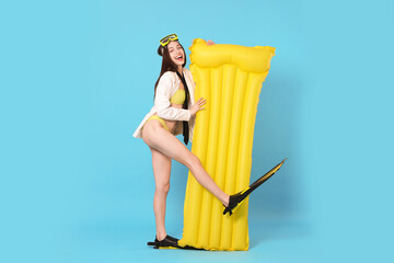 Businesswoman with diving mask, air mattress and flippers on light blue background © New Africa