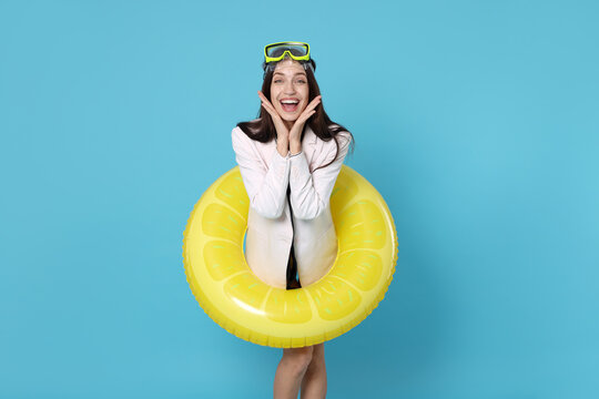 Businesswoman with diving mask and air mattress on light blue background