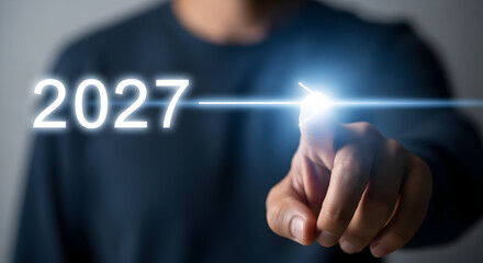 Man Touching the Year 2027 Glowing Digital Interface.
