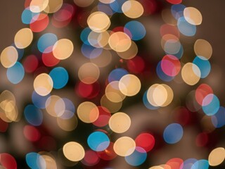 Vibrant festive bokeh lights with red, blue, and yellow circles on a dark background