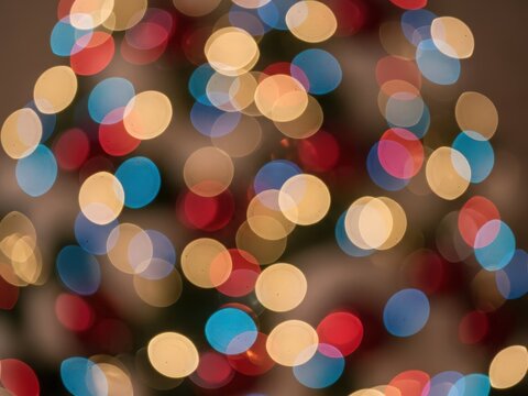 Vibrant festive bokeh lights with red, blue, and yellow circles on a dark background