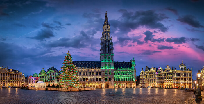 Panoramic view of the illuminated Grande place with City Hall in brussels, Belgium, decorated for Christmas with tree and lights during sunrise without people