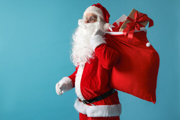 Santa Claus with bag full of gifts on light blue background, space for text. Merry Christmas and Happy New Year