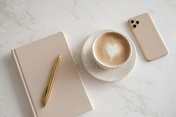 Flat lay of notebook pen coffee and phone on a white marble surface top