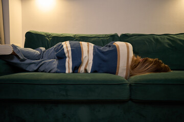 Cozy solitude with woman resting on sofa under soft evening light