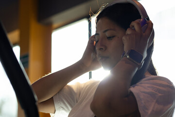 Woman adjusting her headphones while working out on the gym treadmill